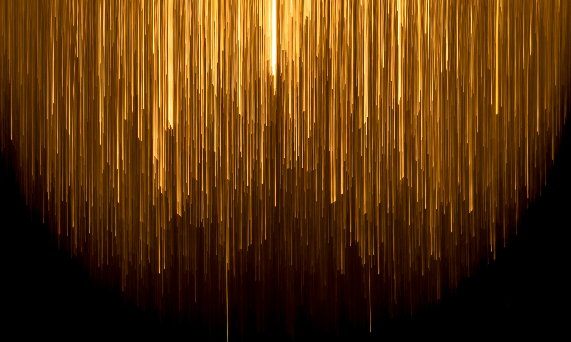 Streaks of golden light falling through darkness